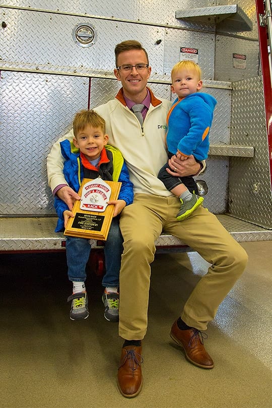 Devin Kack and his kids posing with an award